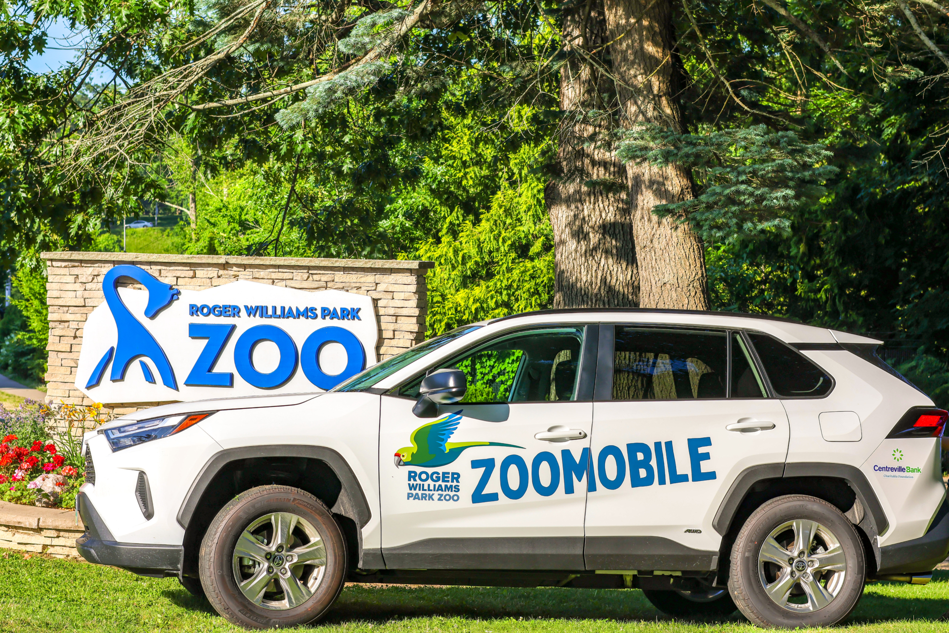 Zoomobile car in front of Zoo's entrance sign