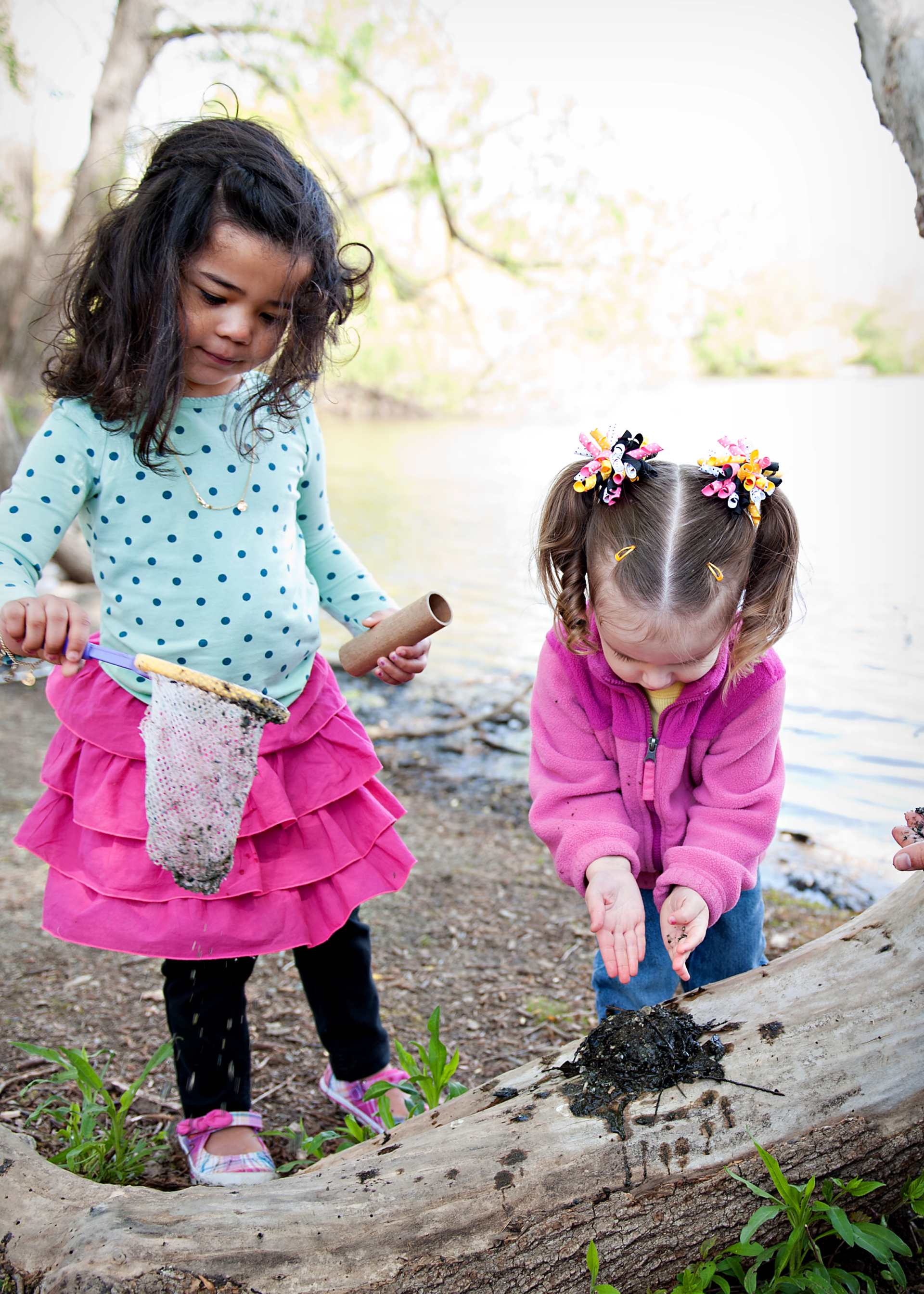 Two young girls playing in nature.