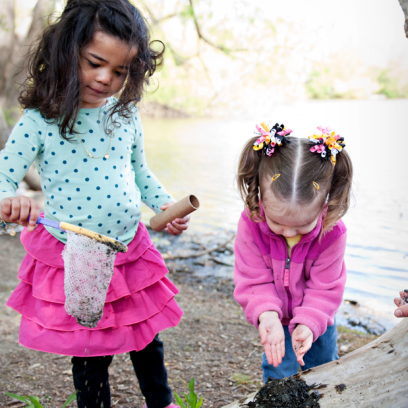 Two young girls playing in nature.