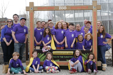 Earth Agents families posing and smiling while wearing their purple Earth agents shirts.