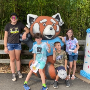 Four Zoo visitors posing with 150th birthday roger mascot.