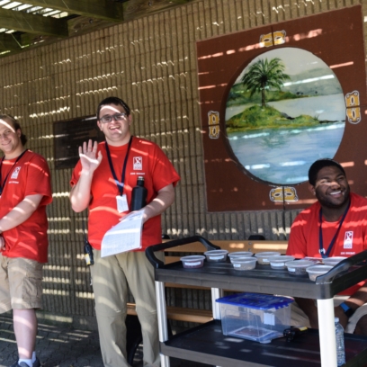 Zoo docents smiling and waiving while volunteering at the Zoo.