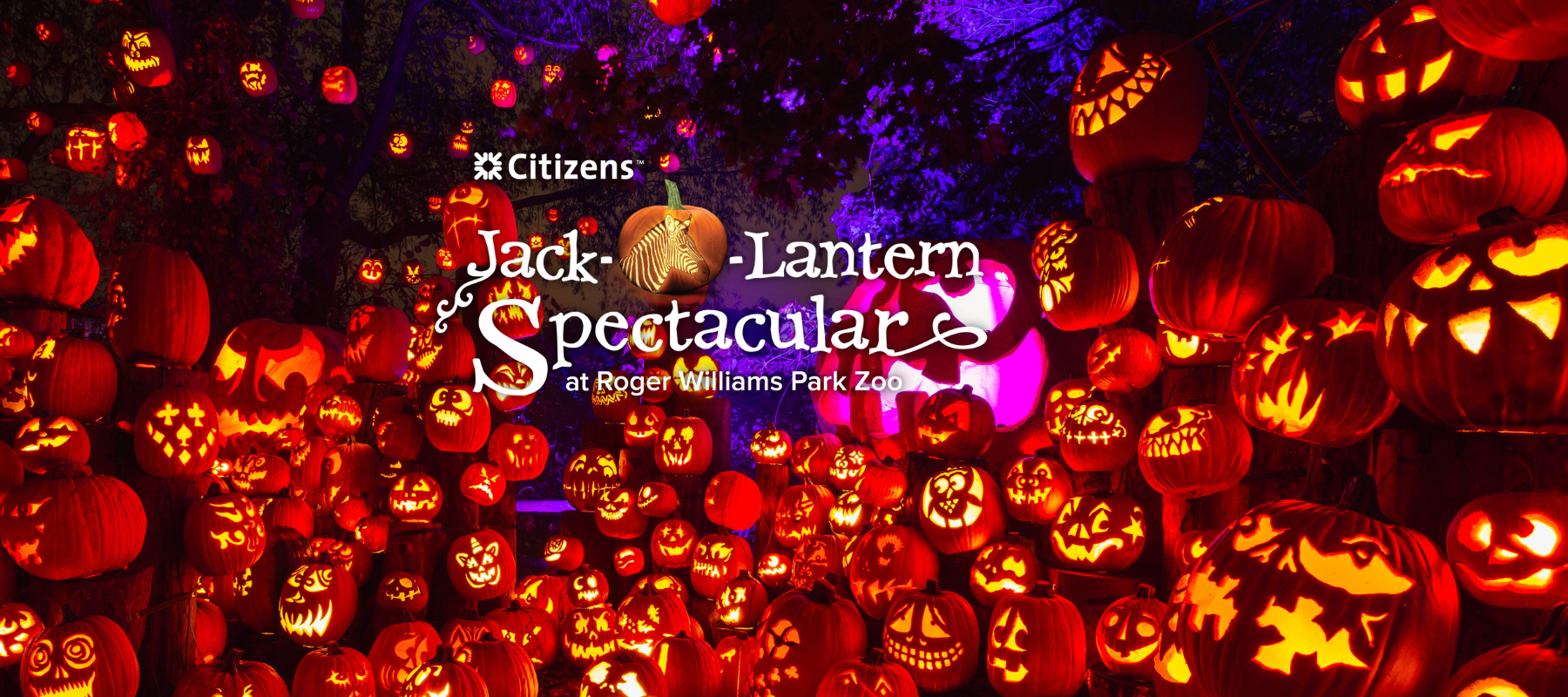 2022 Jack-O-Lantern Spectacular Banner with logo and large display of intricately carved pumpkins lit up.