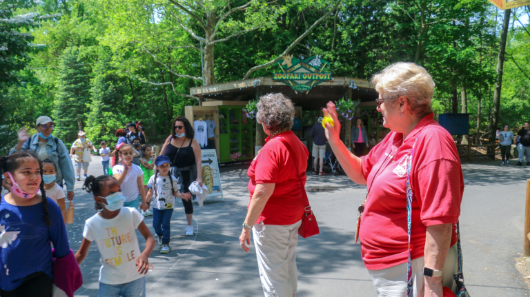 Two Zoo Docents interacting with Zoo guests near Zoo entrance.