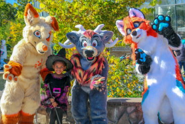 Child dressed as a witch posing with three different animal costumes at Spooky Zoo.