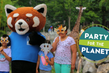 Three children posing with Roger Williams Park Zoo mascot in front of giraffe habitat. Image includes Party for the Planet logo.