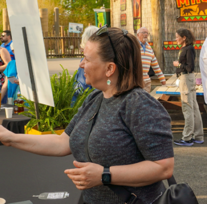 Whisky sommelier handing a guest a glass of whisky, with other event attendees in the background