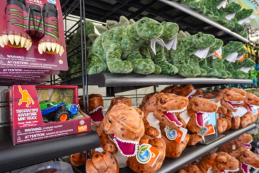 Dinosaurs Among Us gift tent wall with stuffed dinos plush and other dino souveneirs.