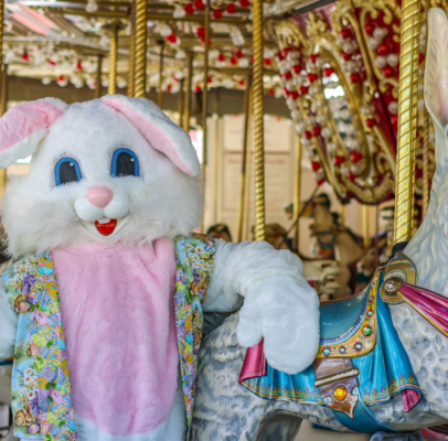 easter bunny costumed character near a carousel