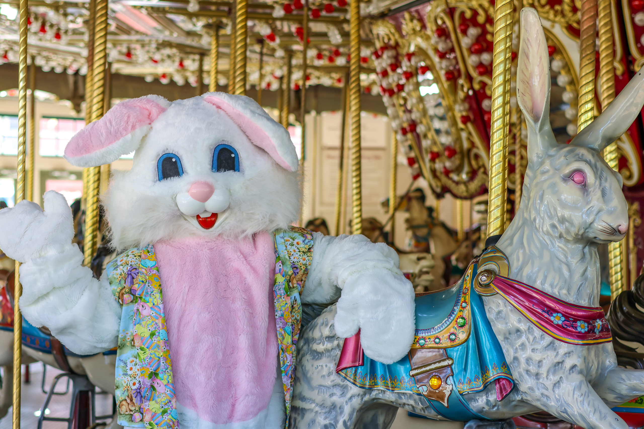 easter bunny costumed character near a carousel